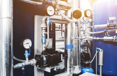 Su arıtma pompası ve basınç kontrolü için basınç göstergeleri olan borular. Genişleme Tank Havalandırma Sistemi. Güneş ışığıyla mavi tonlama