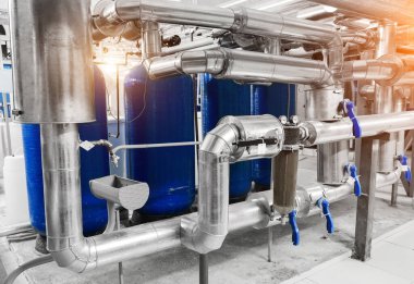 Modern endüstriyel kazan dairesi. Su arıtma boruları ve basınç kontrol için yerleştirilmiş basınç göstergeleri. Su arıtma aygıtı.