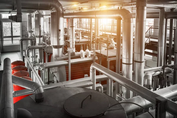 interior of boiler room with gas boilers and pipes for supplying gas and steam.  View from above with sun flares