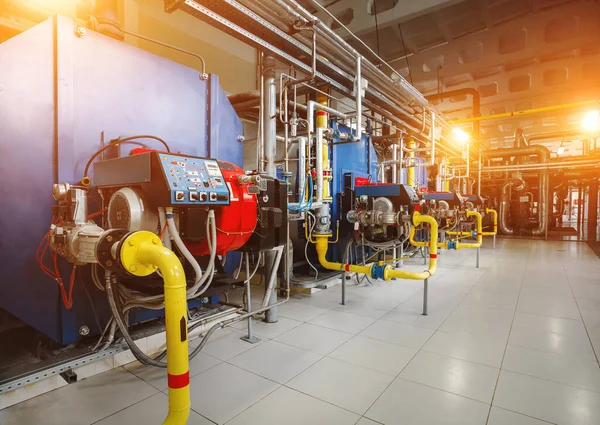 Isınma işlemi için donanımlı modern endüstriyel gaz kazan dairesi. Gaz kazanları art arda ısınıyor, boru hatları, vanalar, güneş patlamaları