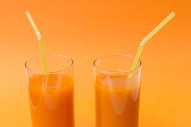 İki bardakta taze havuç suyu, taze havuç.