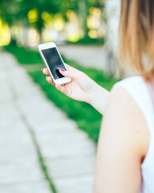 Dokunmatik ekran telefon açık havada şehir parkında kullanarak yakın çekim kadın eller