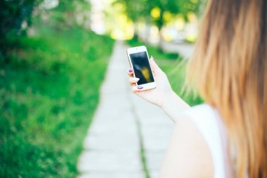 Dokunmatik ekran telefon açık havada şehir parkında kullanarak yakın çekim kadın eller