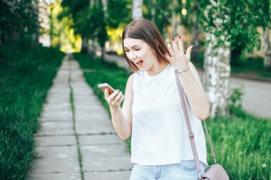 Cep telefonu yavaş aşağı çığlık öfkeli modern güzel kadın. Stresli ve depresif kız parkta