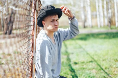 Genç yakışıklı adam giyen siyah şapka büyüleyici ve poz