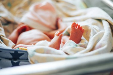 Hastane odasında yenidoğan bebek. Yatak başında beşik uyuyan bebek. Küçük çocuk ya da kız