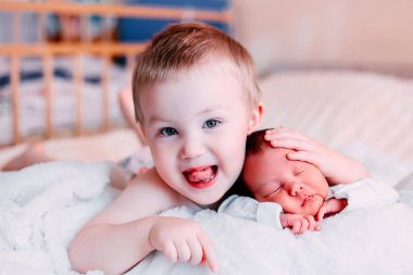 Küçük bir çocuk, yeni doğan bebek kardeşi ile oynuyor. Mutlu aile kavramı.