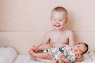 küçük kardeşi yatakta ev aile kavramı aşk, onun elinde tutan yaşlı küçük sarışın bebek kardeşi çocuk