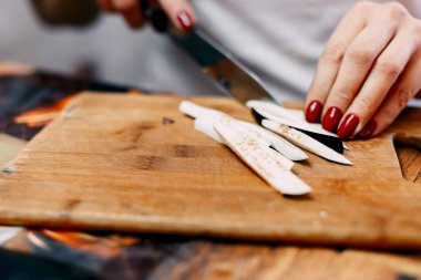 Tanınmayan kadın tarafından ahşap masa üzerine patlıcan kesme.