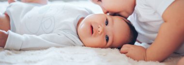 siyah saçlı küçük bacım ile evde yatakta oynayan çocuklar beyaz giysiler uzun büyük ağabeyi sarışın çocuk evlat