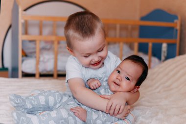 ağabeyi ile yenidoğan oynuyor. sevimli çocuk sevgiyle küçük kardeşi ile oynuyor. sevgi ve büyük ve küçük kardeşleri arasında dostluk kavramı