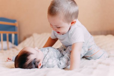 ağabeyi ile yenidoğan oynuyor. sevimli çocuk sevgiyle küçük kardeşi ile oynuyor. sevgi ve büyük ve küçük kardeşleri arasında dostluk kavramı