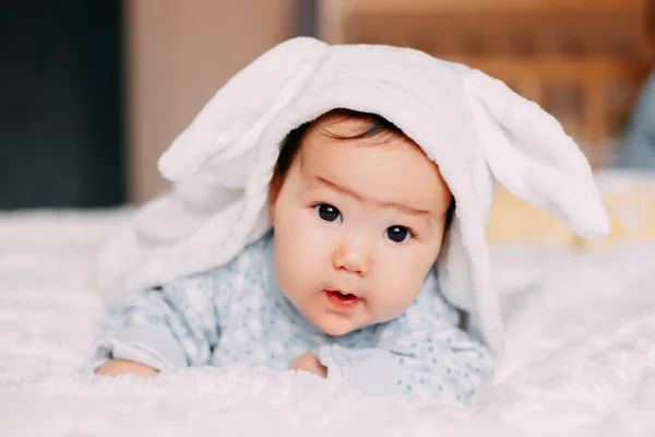 Sorrindo bebê bonito criança em traje de coelho deitado na pele — Fotografia de Stock