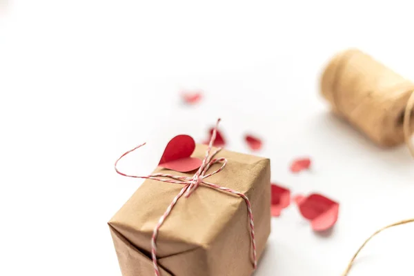 Ремесло подарочная коробка галстук лук с конопли веревки на белом выбранный фокус красный маленький бумажный сердца — стоковое фото
