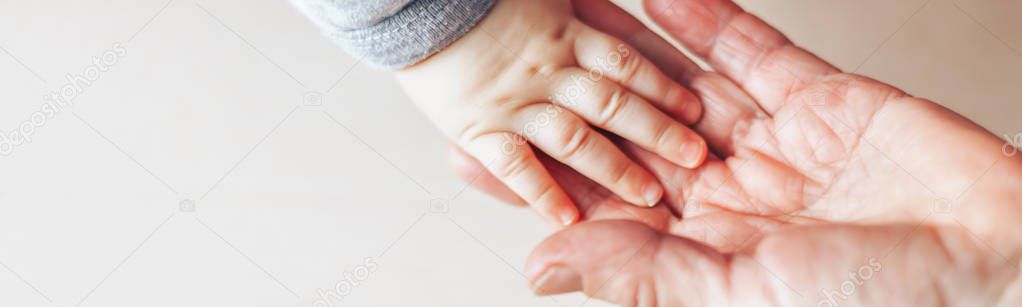 An old woman and a kid holding hands together selected focus on table long banner