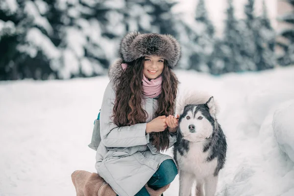 Dívka v klobouku srst s černou a bílou husky — Stock fotografie