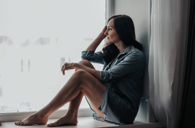 Güzel esmer genç kız gri gömlek için evde fotoğraf stüdyosu poz