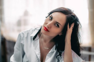 Güzel esmer genç kız beyaz gömlek için evde fotoğraf stüdyosu poz