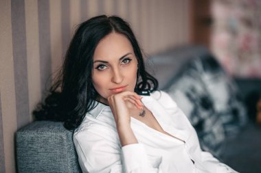 Güzel esmer genç kız beyaz gömlek için evde fotoğraf stüdyosu poz