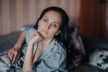 Güzel esmer genç kız gri gömlek için evde fotoğraf stüdyosu poz