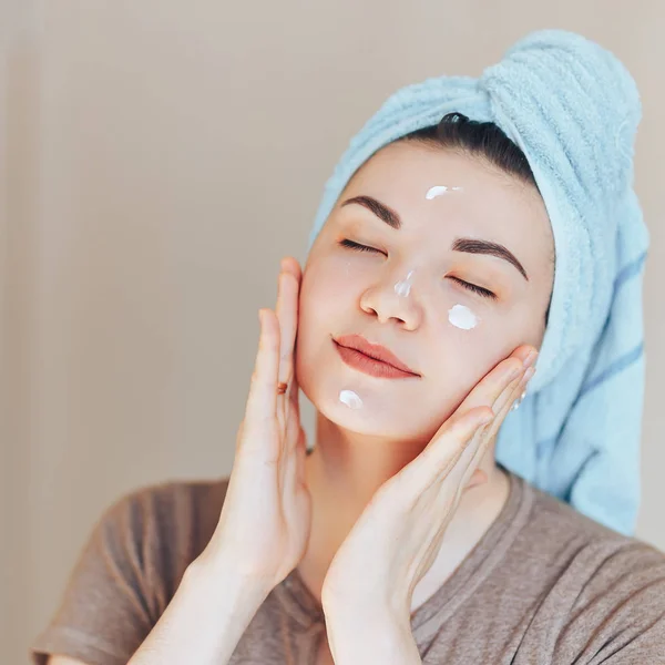 Szczęśliwy uśmiechający się bardzo piękne woman dziewczyna z ręcznikiem na głowie uśmiechający się zdrowy dotyk czysty soft nawilżona nawilżona skóra opieki po zastosowaniu kremu na twarzy młodych — Zdjęcie stockowe