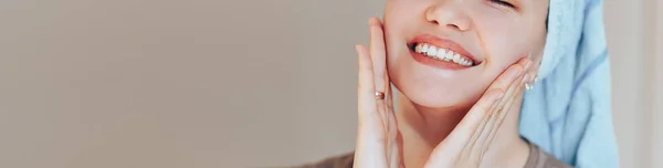 Close up shot of glad satisfied woman being happy after spa procedure, has fresh soft healthy skin, broad smile, white perfect teeth touch her face look at camera. long banner — Stock Photo, Image