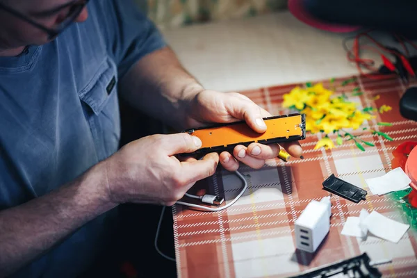 Чоловік ремонтує руки зробити зламаний телевізор віддаленим — стокове фото