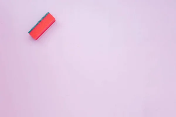 Een rode schotel wassen keuken spons op roze achtergrond kopie ruimte flatlay — Stockfoto