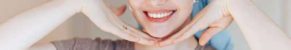 Close up shot of glad satisfied woman being happy after spa procedure, has fresh soft healthy skin, broad smile, white perfect teeth touch her face look at camera. long banner — Stock Photo, Image