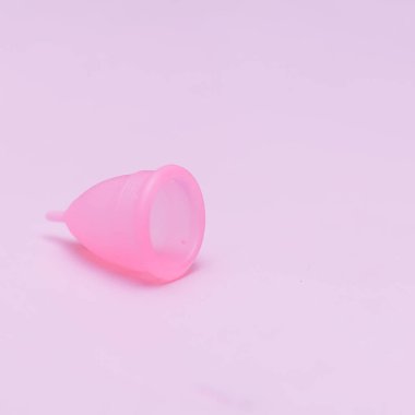 Pink arka planda pembe menstrüel fincan. Dönemde alternatif kadınsı hijyen ürünü. Kadın sağlığı konsepti