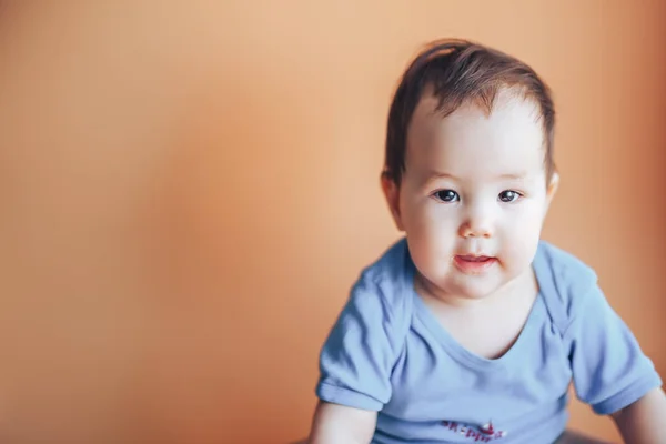 Mooie kleine meisje of jongen met donker haar lachend op een helder oranje achtergrondkleur van 2019 met ruimte voor tekst tevreden glimlach blik op camera — Stockfoto