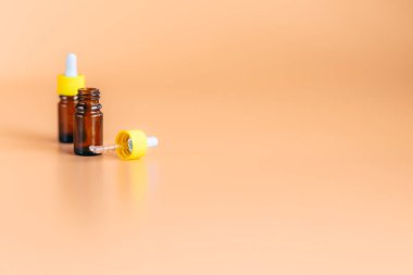 iki cam damlalık serum şişesi üzerinde kırpma yoluyla kozmetik ürün tasarımı için hazır ya da burun için tıbbi turuncu arka plan