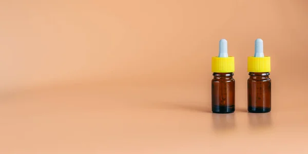 Дві скляні пляшки сироватки на помаранчевому фоні з відсічним контуром готові для косметичного дизайну продукту або медичні для носа — стокове фото