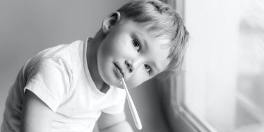 Ateşi yüksekliğini ölçme ve kamera siyah ve beyaz fotoğraf bakarak hasta genç çocuk ile bir thermomether