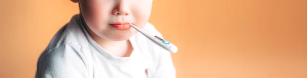 Malo niño pequeño con un termómetro, midiendo la altura de su fiebre y mirando a la cámara — Foto de Stock