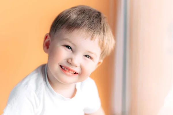 Πορτρέτο του ξανθιά ευτυχισμένη χαρούμενη όμορφη χαριτωμένο μικρό αγόρι βλέπουν φωτογραφική μηχανή σε πορτοκαλί φόντο — Φωτογραφία Αρχείου