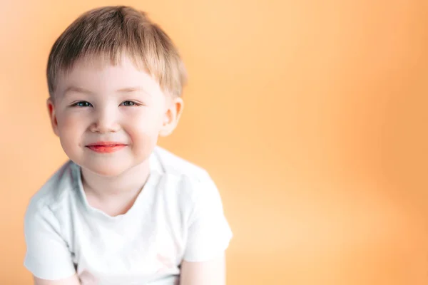 Πορτρέτο του ξανθιά ευτυχισμένη χαρούμενη όμορφη χαριτωμένο μικρό αγόρι βλέπουν φωτογραφική μηχανή σε πορτοκαλί φόντο — Φωτογραφία Αρχείου