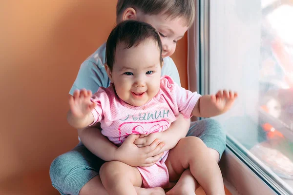 Küçük kardeşi oynayan ve birlikte gülümseyen sarılma ağabeyi. aile kavramı aşk korumak — Stok fotoğraf