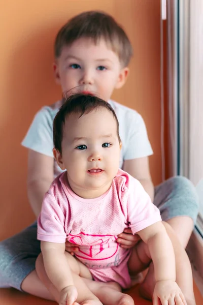 Hermano mayor abrazando a su hermanita jugando y sonriendo juntos. concepto de familia amor proteger —  Fotos de Stock