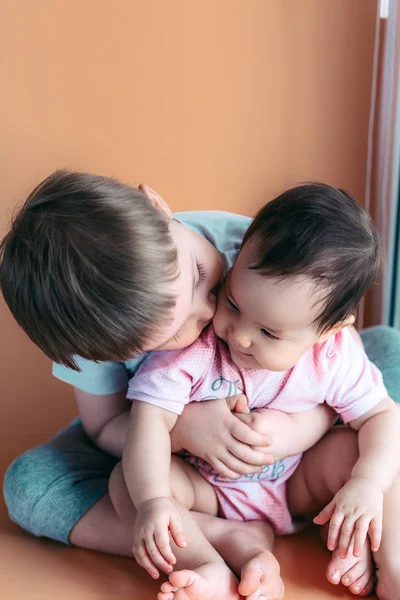 Gelukkig spelen broertje knuffels zijn zus baby, jongen en meisje omarmt kussen, concept liefde en ouderschap — Stockfoto