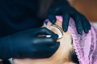 Master Microblading, mikropigmentasyon kaş hazırlanmak. müşteri kaş beyaz kalem üzerinde kadın Drow, kaşlar için yarı kalıcı makyaj. Kaş odaklanmak