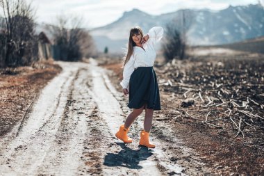 Gri etek ve lastik çizmeler ile güzel bir genç kadın ülkede bir çayır yürür. Dans eder, güler ve özgürlük yayar.