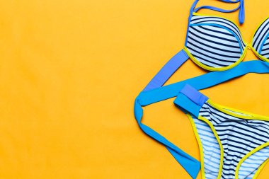 sarı arka plan üzerinde çizgili renkli mayo, flatlay, metin için alan, yaz geliyor