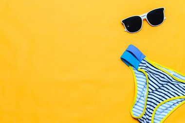 Sarı arka plan, flatlay, copyspace, vintage kamera, beyaz güneş gözlüğü ve mayo yaz aksesuarları kavramı