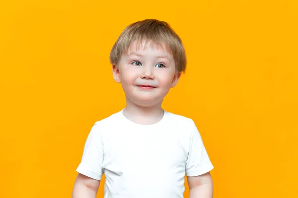 Retrato de niño feliz sonriente 3 años raza mixta medio asiático medio caucásico sobre fondo amarillo con pelo rubio y ojos verdes — Foto de Stock