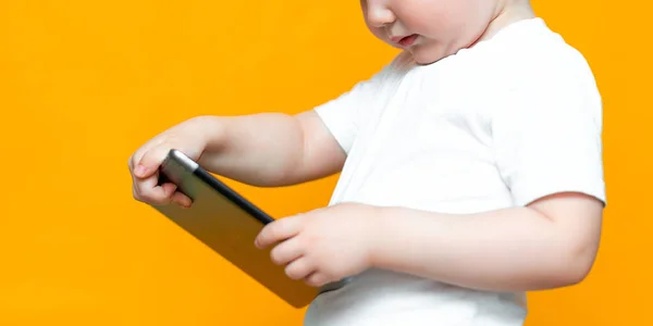 Misturado menino loira racial usando tablet pc no fundo amarelo — Fotografia de Stock