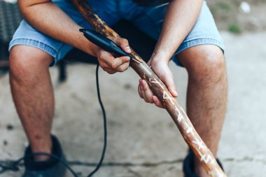 oyma elmas söğüt baston. Ahşap şeyler üzerinde rünye yapan adam