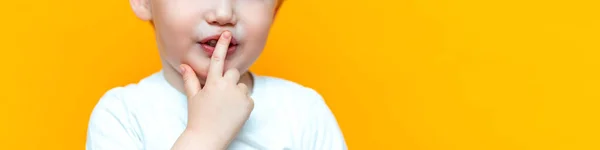 Küçük çocuk çocuk dudaklarına parmağını koymak, sessizlik ciddi tutmak, sarı saç — Stok fotoğraf