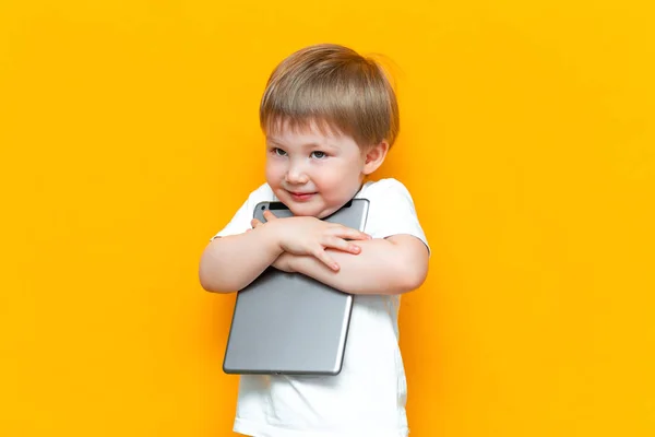 Feliz chico lindo abrazando su encantadora PC tableta, generación Z, niños que nació con la tecnología —  Fotos de Stock