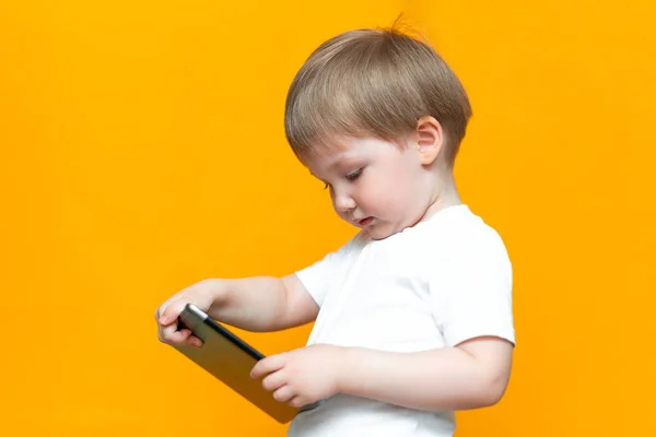 Mezclado racial rubia chico usando tableta pc en amarillo fondo —  Fotos de Stock